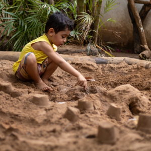 criança brincando em uma caixa de areia